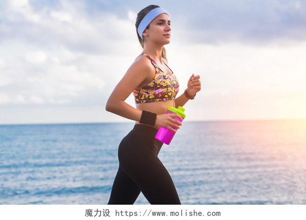 在海边跑步的女人年轻人适合女孩在日出时在海滩上运行